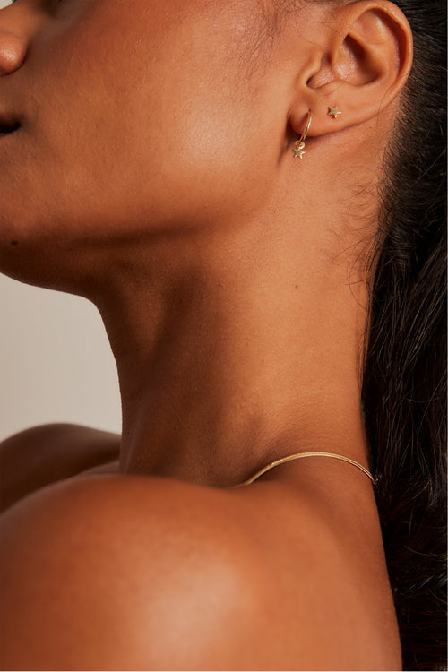 Model wears a star stud earring set. 