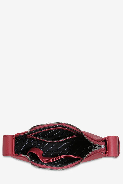 Red belt bag with open zipper on a white background