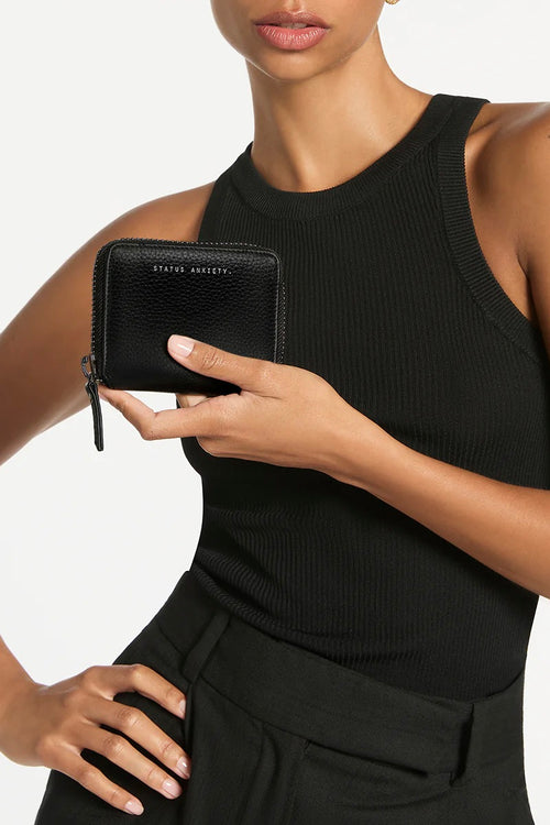 model holds black leather wallet