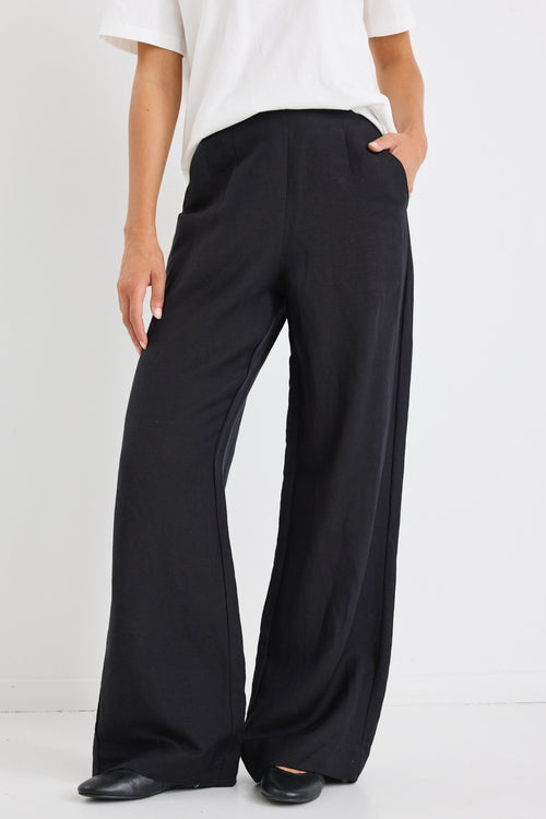 model wears a black linen wide leg pant and a white t-shirt