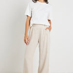 model wears natural linen pants with white top