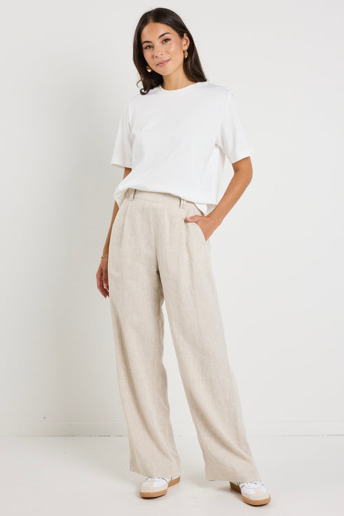 model wears natural linen pants with white top