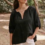 model wears a black linen shirt