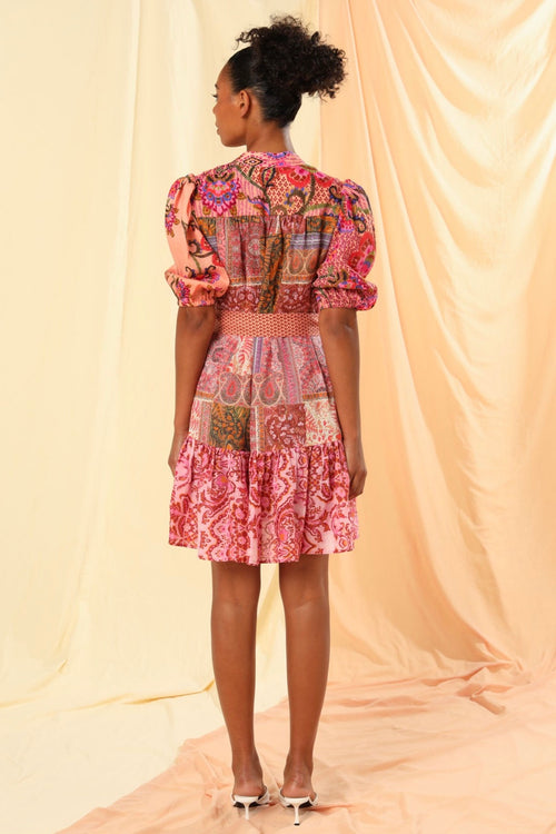 the model is wearing a pink floral mini dress