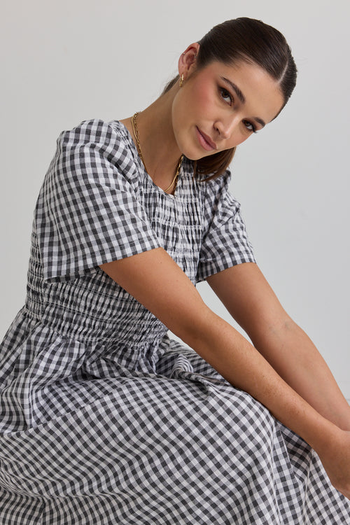 model wears a black gingham midi dress