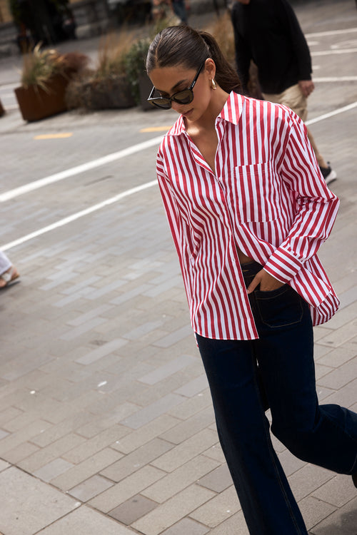 Woman wearing a red and white stripe oversized shirt 