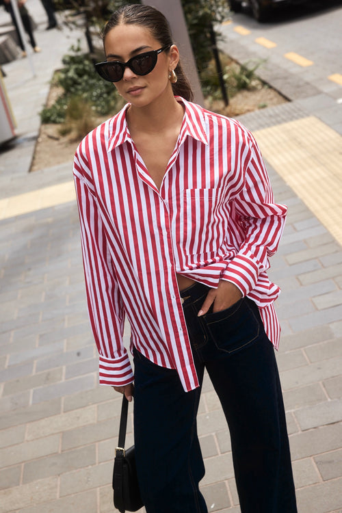 Woman wearing a red and white stripe oversized shirt 