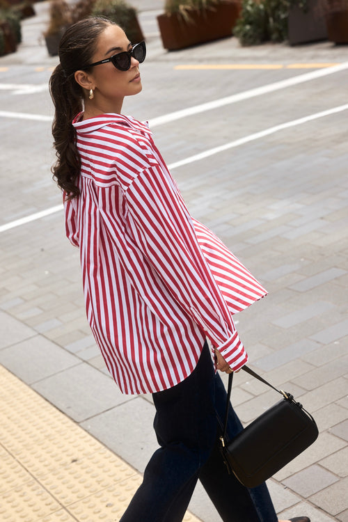 Woman wearing a red and white stripe oversized shirt 